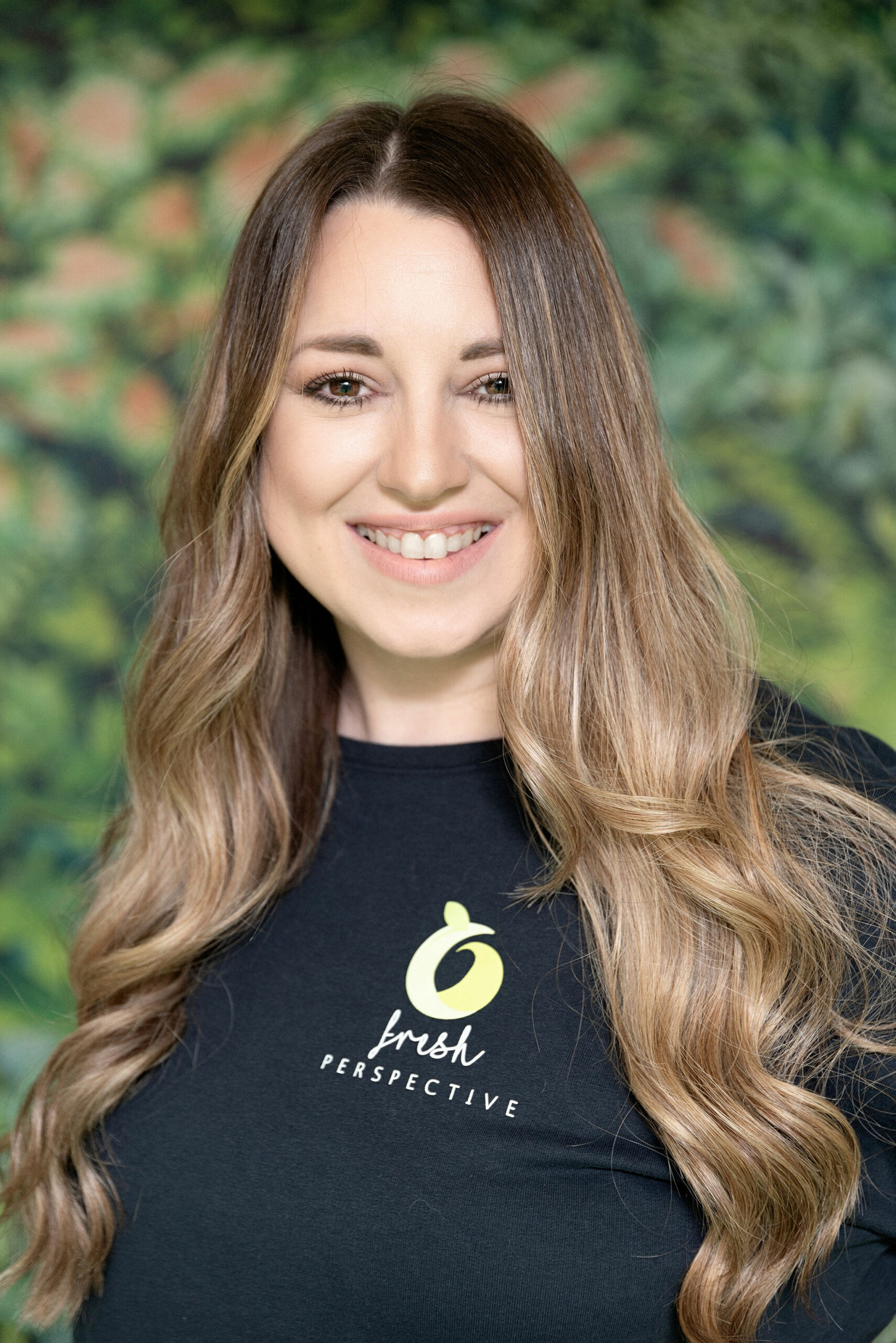 Meet The Team - Fresh Perspective Talent Seeker - Lyndsey stood with a green jumper on in front of a leaf wallpaper